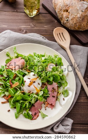 Lamb\'s lettuce salad with roasted nuts, smoked rump and poached egg, rustic italian bread with olives