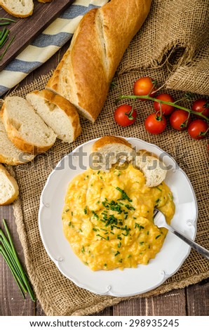 French style scrambled eggs with chives with french baquette and mini tomatoes