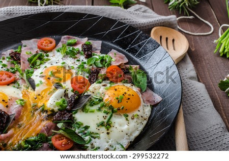 Fried eggs with ham and herbs, mini tomatoes and lots of herbs