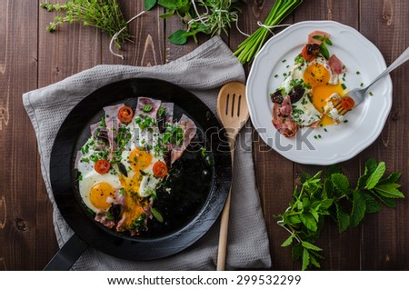 Fried eggs with ham and herbs, mini tomatoes and lots of herbs