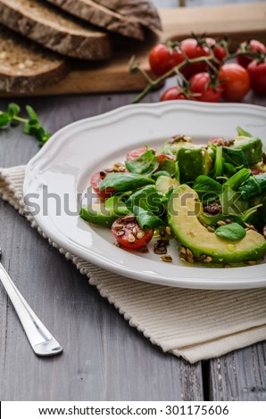 Summer salad of avocado, tomato, peanuts and lamb lettuce salad, whole grain bread for maximum healthy, topped extra virgin olive oil
