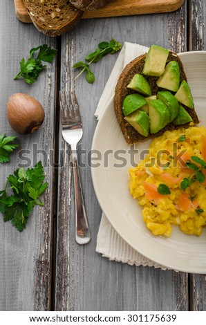 Scrambled eggs with smoked salmon and whole wheat toast with avocado and lemon