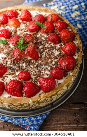Summer strawberry cheesecake stuffed by nuts and almonds, topped with chocolate shavings