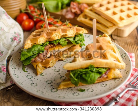 Waffles sandwich with bacon, chicken and fresh salad