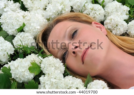 Young woman laying in flowers - snowballs