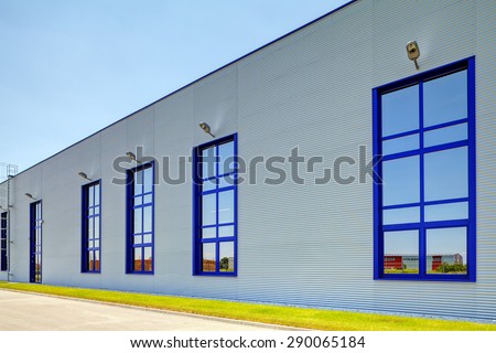 Details of gray facade made of aluminum panels  with doors and windows on industrial building