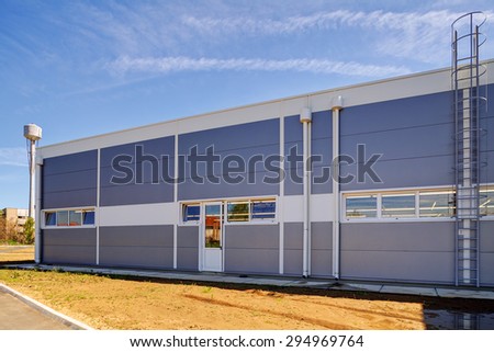 Details of gray facade made of aluminum panels  with doors and windows on industrial building