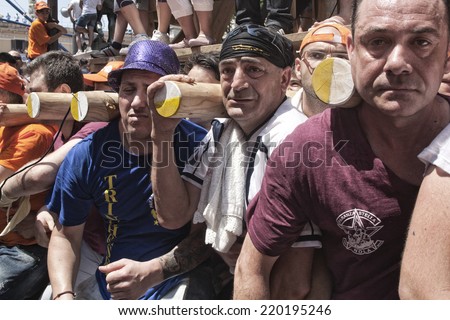 NOLA, ITALY - JUNE 24, 2012: Gigli Parade is a popular festival during of the celebrations for St Paul. Traditional procession of lilies, wooden obelisks 25 mt high carried on the 120 men shoulders