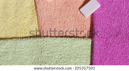 Stack of fresh clean towels and scented soap isolated on white background