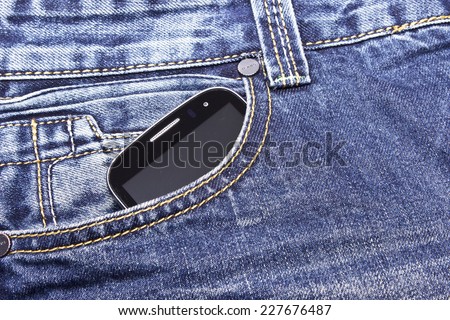 Mobile phone in the pocket of blue jeans