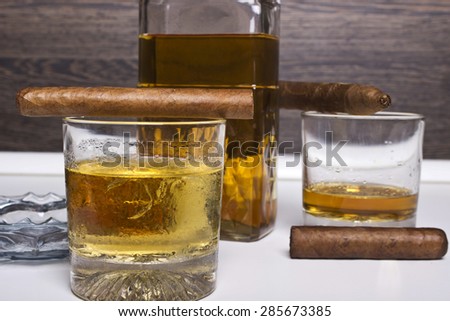 Decanter of whiskey and a glass with cuban cigar