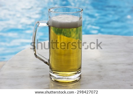 beer mugs by swimming pool in tropical resort