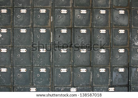 Many rows of old fashioned mailboxes that are weathered and worn