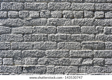 A brick wall sprayed with white stucco