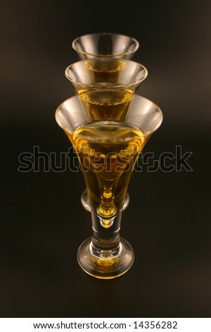 Three cordials in a row with gold liquid