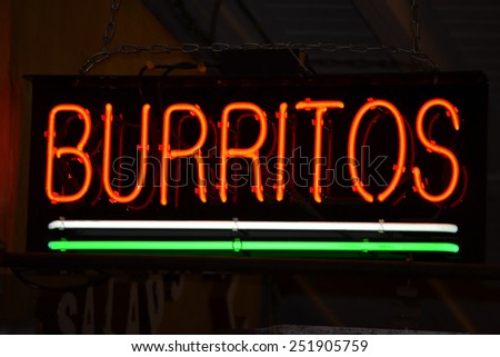 An red neon sign that reads Burritos