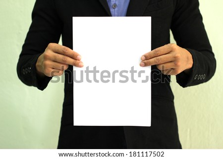 Business man holds paper with copy space  (focus on hand holding paper )