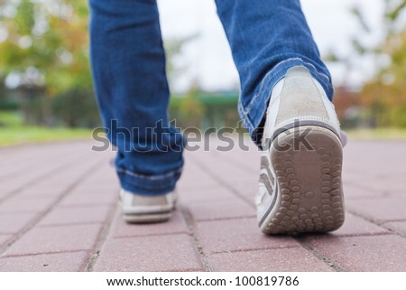 Walking in sport shoes on pavement in spring day