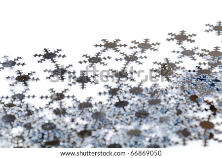 Christmas decoration of silver confetti snowflakes against white background with nice bokeh