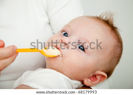Mother feeding her picker son with spoon, but he refusing to eat