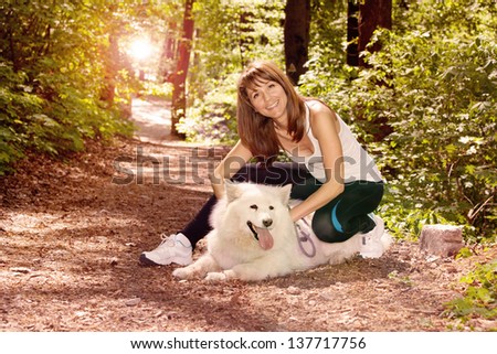 Female model in forest with Samoyed dog