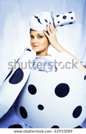 Young woman standing in a box with an interesting hat