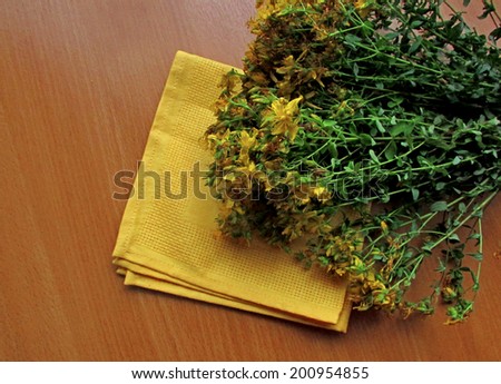 A bunch of herbs lies on the wooden table