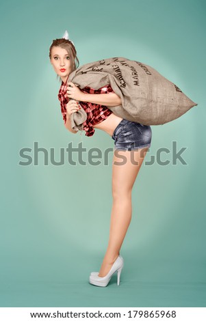 Pin up girl holding heavy bag