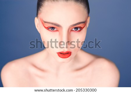 Creative makeup, girl with bright makeup on a blue background,