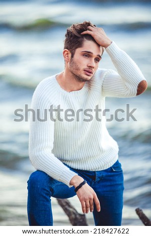 handsome man against the sea, autumn beach