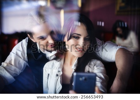 Friends taking picture of themselves with smartphone, couple in love