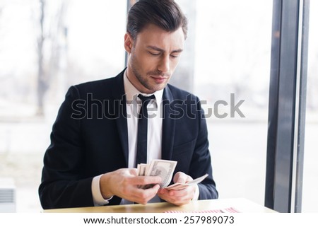 businessman counting his money, brunette handsome man in a suit with money