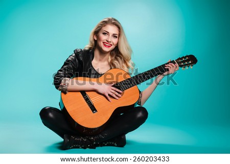 girl having fun in the studio with a guitar. musical instruments. concept. rock. blonde