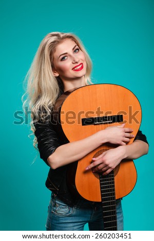 girl having fun in the studio with a guitar. musical instruments. concept. rock. blonde