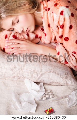 sick beautiful girl sleeping in the bed next to medicines, napkins and tablets. concept. girl sick in bed