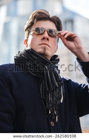 Young handsome businessman posing, Portrait of fashion man on street, blurred city background