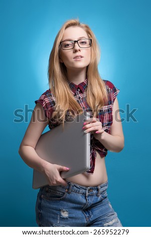 beautiful girl student with a laptop on a blue background