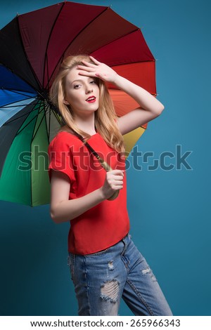 Close up portrait of beautiful blond female with rainbow umbrella background