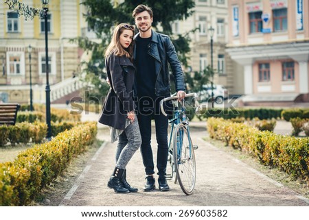 Outdoor lifestyle portrait of young couple in love standing in old town on the street, bike, hipsters, lifestyle, youth