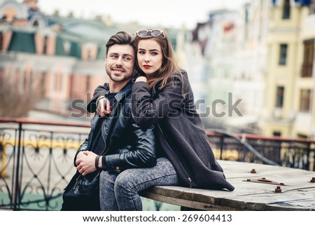 Outdoor lifestyle portrait of young couple in love  in old town on the street, couple sitting, city, europe