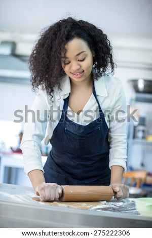 A young girl learns to cook cakes in the bakery