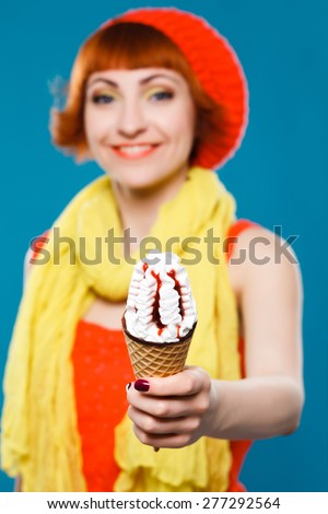 studio portrait. French woman wearing beret. blue background. bright woman. ice cream