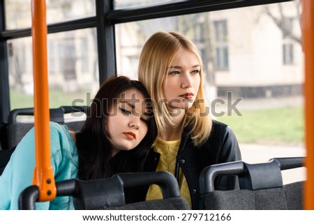 wo beautiful girls riding public transportation to work . study. friendship, joy,
