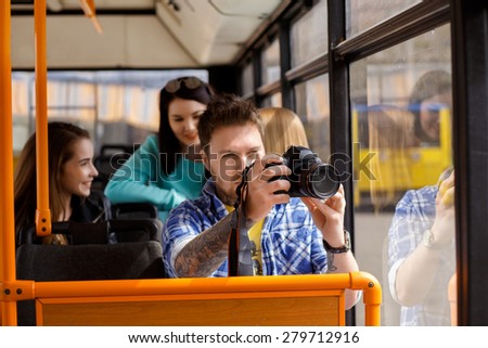 Male tourist photographing the city from the window of the bus