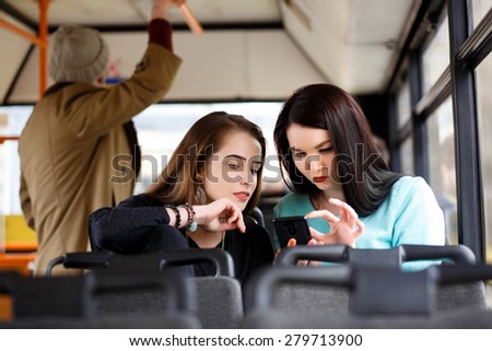 wo beautiful girls riding public transportation to work . study. friendship, joy,
