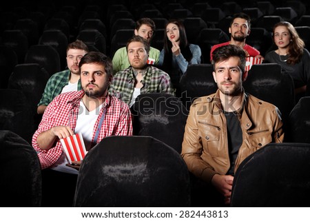 merry company in the cinema,\
young people watch movies, film,