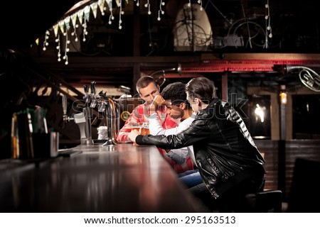 friends drink beer and spend time together in a bar.  sadness at the bar