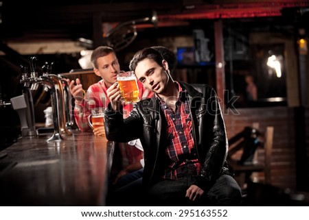 friends drink beer and spend time together in a bar.  sadness at the bar