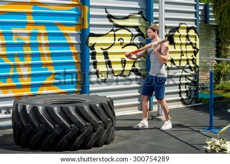 Sledgehammer Tire Hits men workout at gym with hammer and tractor tire