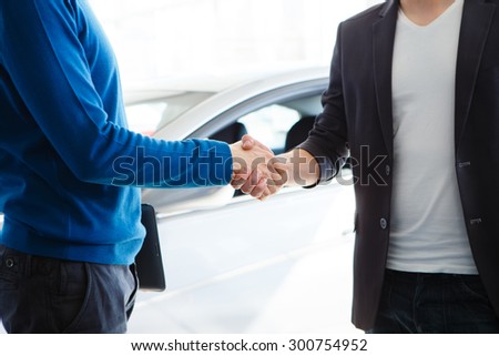 Good deal. Close-up shoot of the hands shaking in front of the car